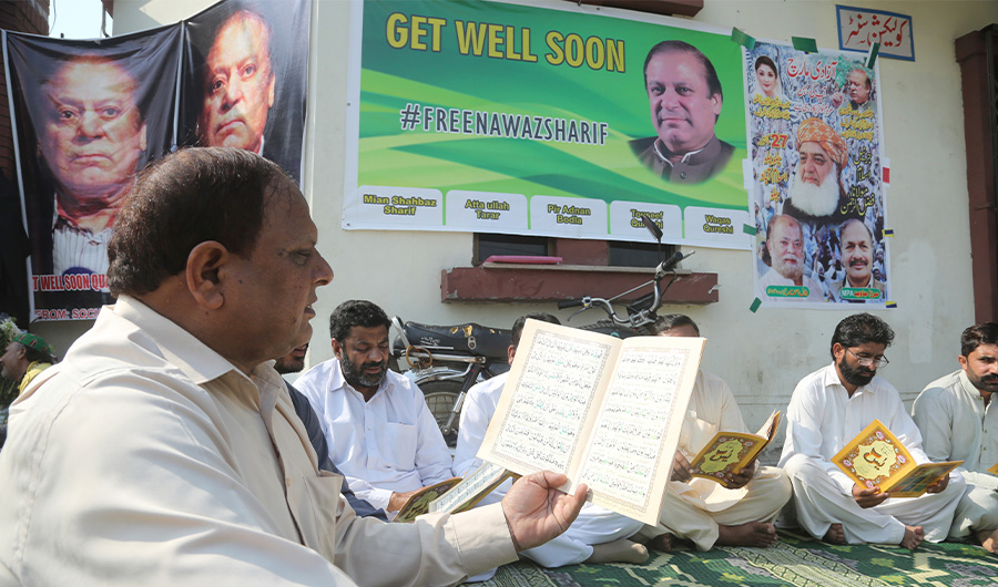 Supporters of Pakistani former Prime Minister Nawaz Sharif reads Quran for health recovery of their leader, outside a hospital where Sharif admitted in Lahore, Pakistan, Friday, Oct. 25, 2019. (AP)