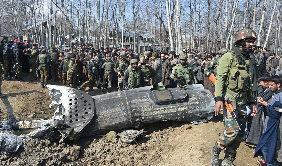 In this file photo taken on February 27, 2019 Indian soldiers and Kashmiri onlookers stand near the remains of an Indian Air Force helicopter after it crashed in Budgam district, outside Srinagar. (AFP)