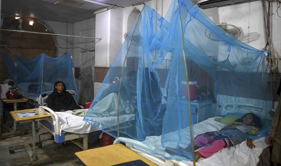 Patients suffering from dengue fever rest on beds under netting as they are being treated at a hospital in Karachi on September 19, 2019. (AFP)