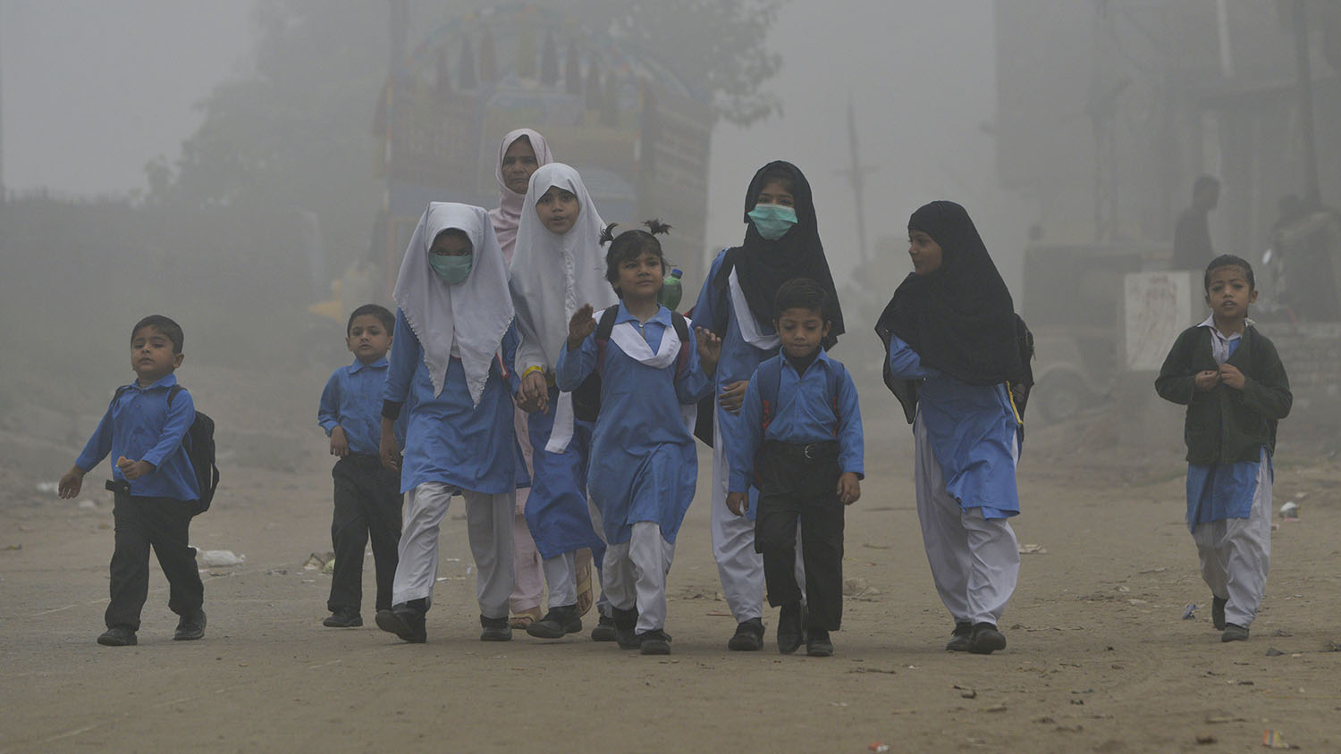In this file photo, Pakistani children walk to school in heavy smog in Lahore on Nov. 6, 2017. Schools were closed in Lahore on Thursday as the city was engulfed by smog once again and the poor quality of air raised alarm about the health of its 11 million residents. (AFP)