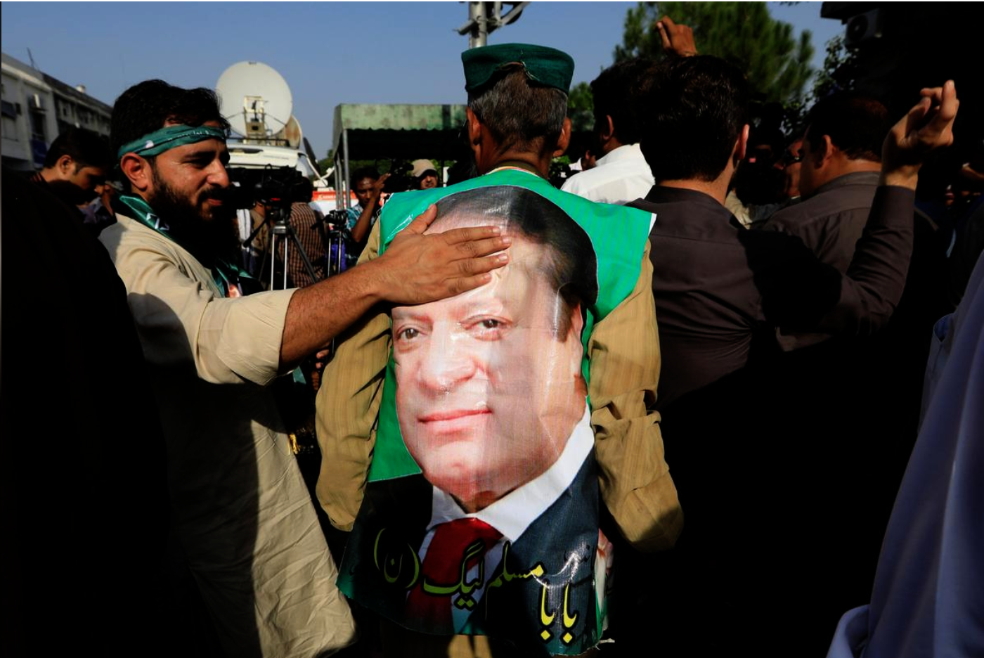 A supporter of former Prime Minister Nawaz Sharif touches his picture as he celebrates with others following the court's decision in Islamabad, Pakistan September 19, 2018. (REUTERS)