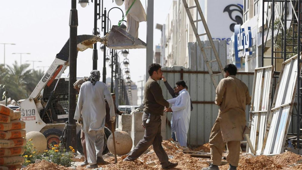 In this file photo, Laborer work to remove a pole outside a residential building in Riyadh on Feb. 9, 2016. (REUTERS)