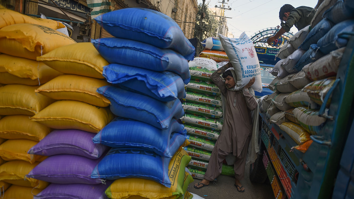 In this file photo, Pakistani workers unload rice sacks at a wholesale market in Karachi on April 8, 2019. (AFP)