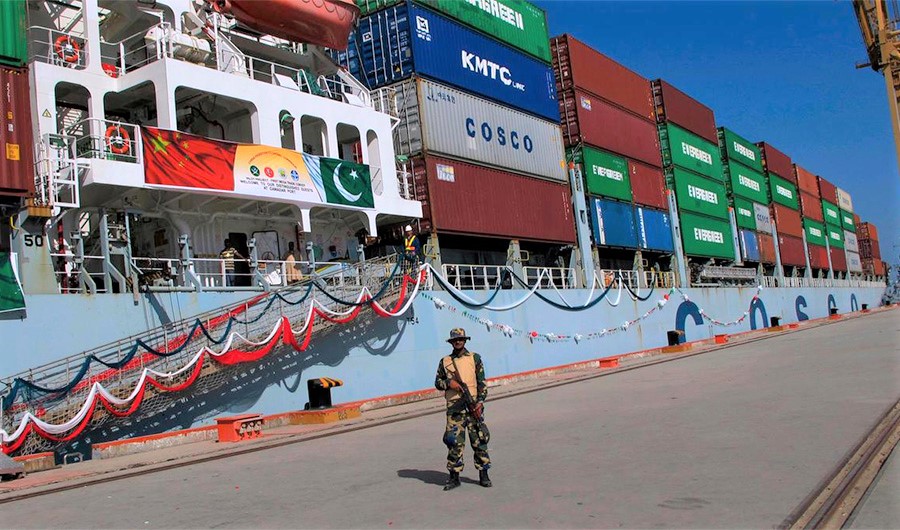 A Pakistan Navy soldier stands guard while a loaded Chinese ship prepares to depart Gwadar port. (AP)