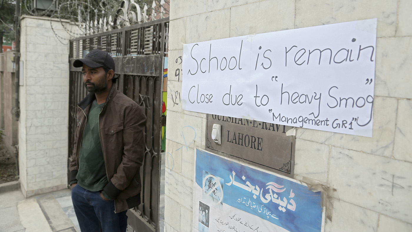 A Pakistani guard stands outside a school that closed down due to heavy smog in Lahore on Nov. 22, 2019. (AP)
