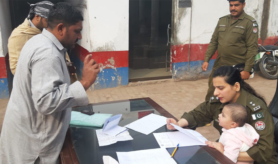 Aisha Butt, a young police officer carrying her infant daughter while performing her job duties in a Police station in Karachi. (Photo Courtesy: Aisha Butt Twitter Account)