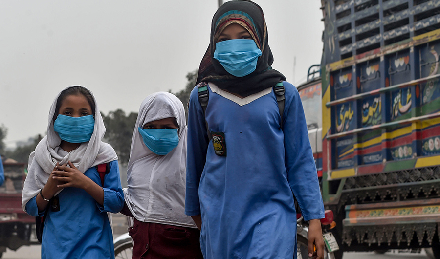 Students wear masks as they go to school amid heavy smog conditions in Lahore on November 14, 2019. (AFP)