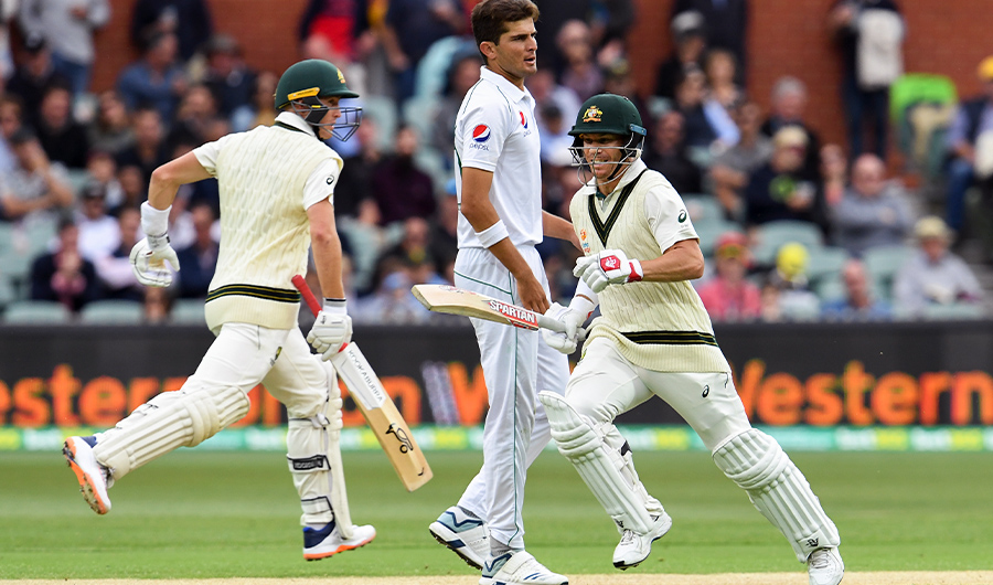 Australia's batsmen Marnus Labuschagne (L) and David Warner take more runs from the Pakistan bowling as Shaheen Afridi (C) looks on on the first day of the second cricket Test match in Adelaide on November 29, 2019. (AFP)