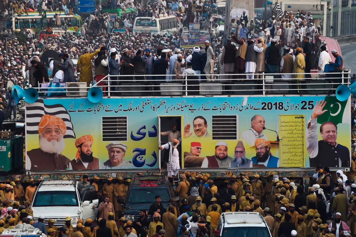 Maulana Fazlur Rehman (C), chief of the Jamiat Ulema-e-Islam party steps down from his container during an anti-government "Azadi March" towards Islamabad, in Lahore on October 30, 2019. Pakistan Prime Minister Imran Khan faces the first major challenge to his leadership as a grey-bearded, orange-turbaned rival he calls "Maulana Diesel" marches to Islamabad with thousands of Islamists hoping to bring down the government. (AFP)