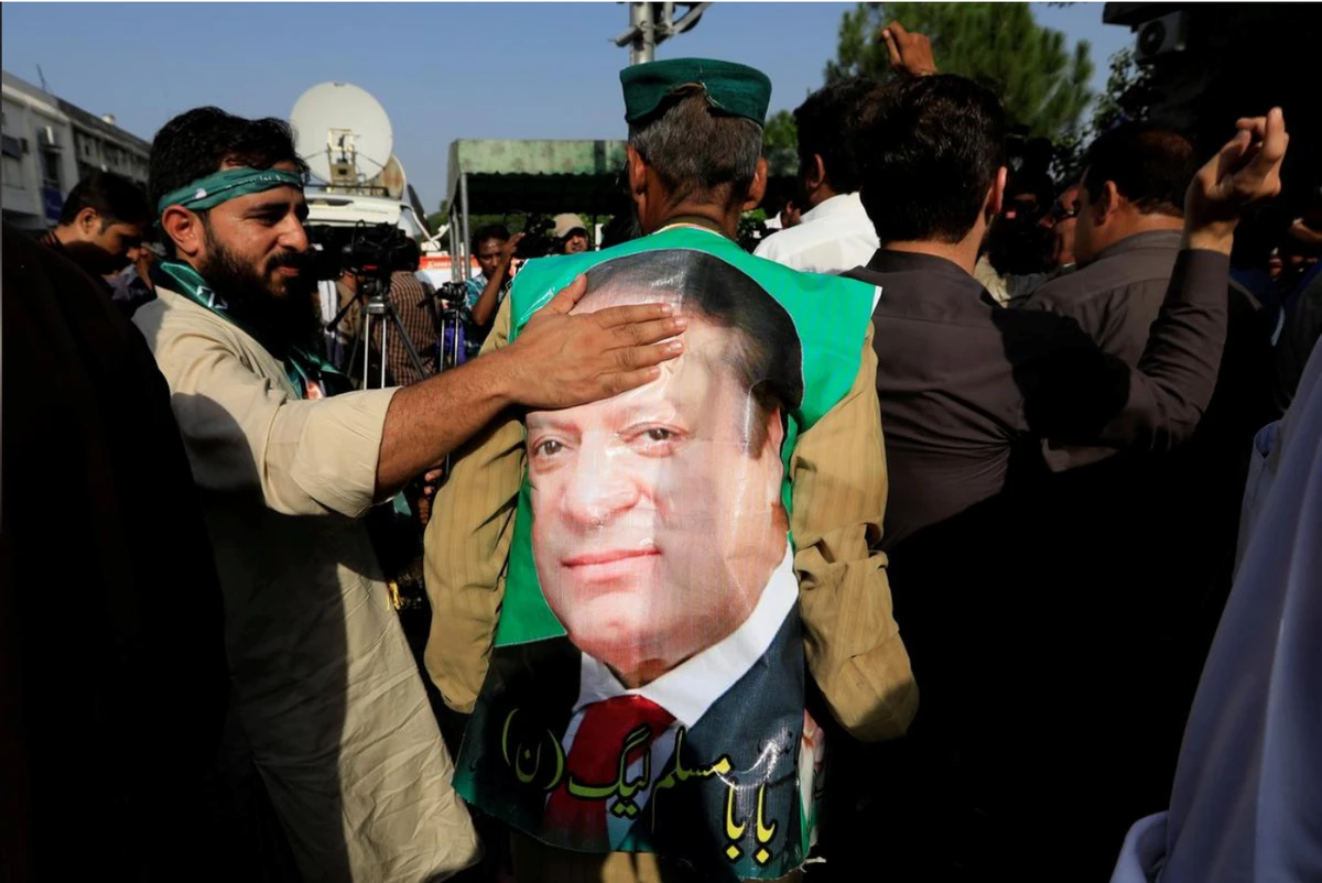 A supporter of former Prime Minister Nawaz Sharif touches his picture as he celebrates with others following the court's decision in Islamabad, Pakistan September 19, 2018. (REUTERS)