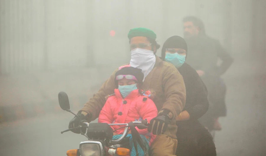 People use face masks to protect themselves from morning smog as they ride on bike along a road in Lahore, Pakistan November 10, 2017. (Reuters)