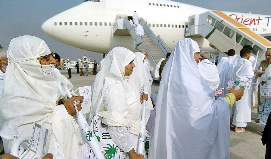 Pakistani Hajj pilgrims walk towards a waiting plane at Lahore International airport, 16 December 2004. (AFP)