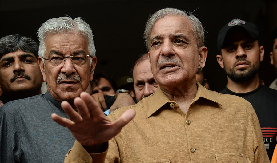 Shahbaz Sharif (R), brother of Pakistani former Prime Minister Nawaz Sharif talks with media representatives as he leaves from the High court, in Lahore on October 25, 2019. (AFP)