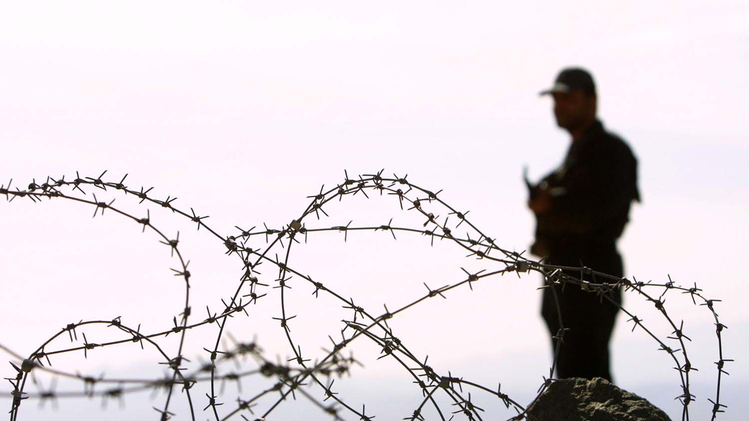 In this file photo, Iranian soldier stands guard on a mound built to prevent drug trafficking in the Mirjaveh point where the borders of Iran, Afghanistan and Pakistan meet, on Dec. 2003. (AFP)