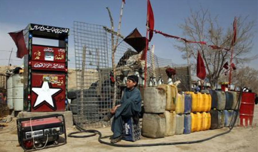 A boy sits next to plastic canisters filled with petrol brought from Iran, while waiting for customers at a roadside petrol station on the outskirts of Quetta, Pakistan Feb 13, 2019. (REUTERS/ File photo)