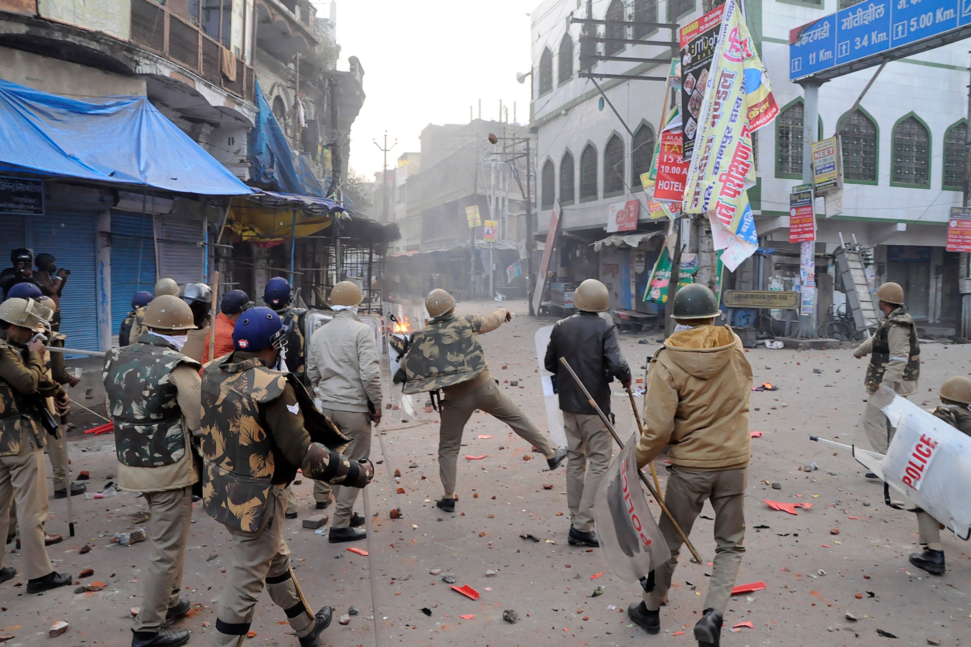 A Policeman throws stones towards protesters during demonstrations against India's new citizenship law in Kanpur on December 21, 2019. (AFP)