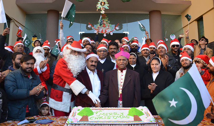 Christian devotees dressed as Santa Claus celebrate as they cut a cake in Quetta on December 22, 2019, ahead of Christmas celebrations. (AFP)