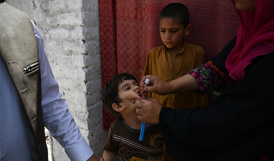 A Pakistani health worker administers polio vaccine drops to a child during a door-to-door polio immunization campaign on the outskirts of Islamabad on April 26, 2019. (AFP)