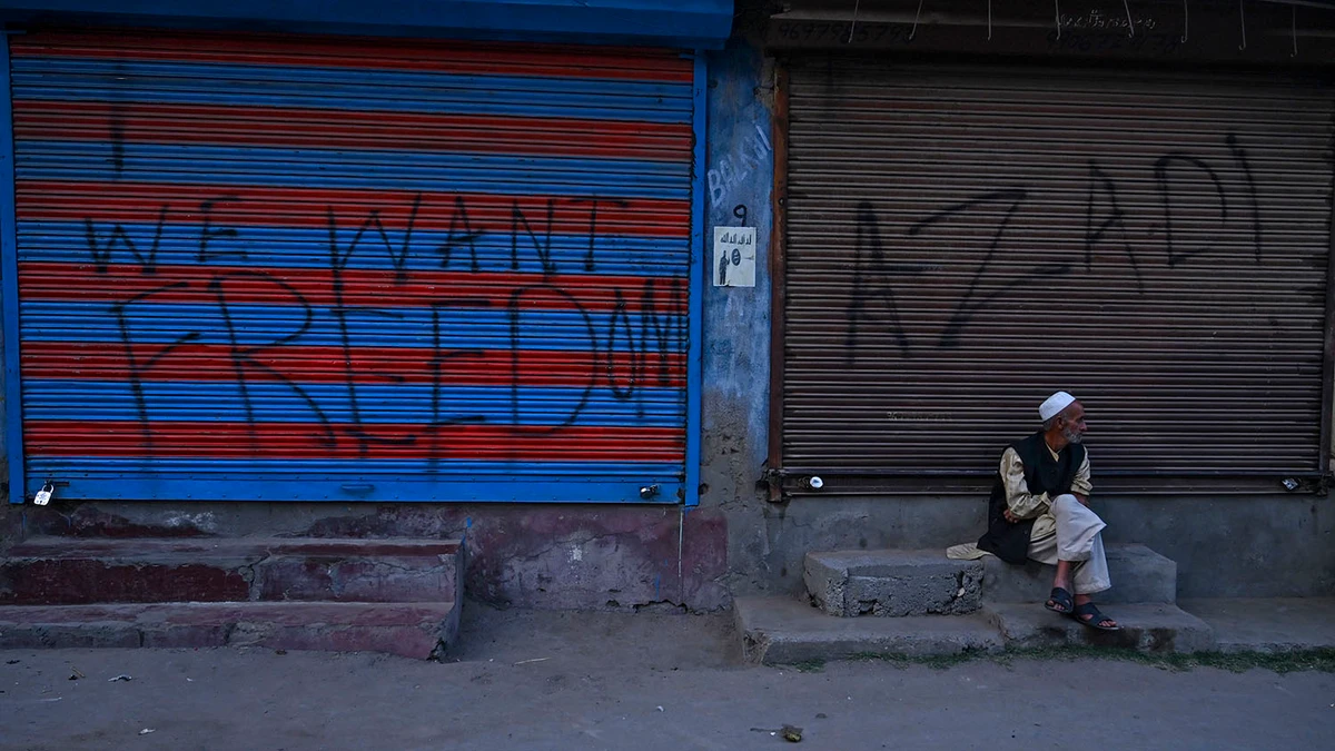 In this file photo, a Kashmiri man sits in front of closed shops during a lockdown at Anchar Soura in Srinagar on Sept. 26, 2019. (AFP)