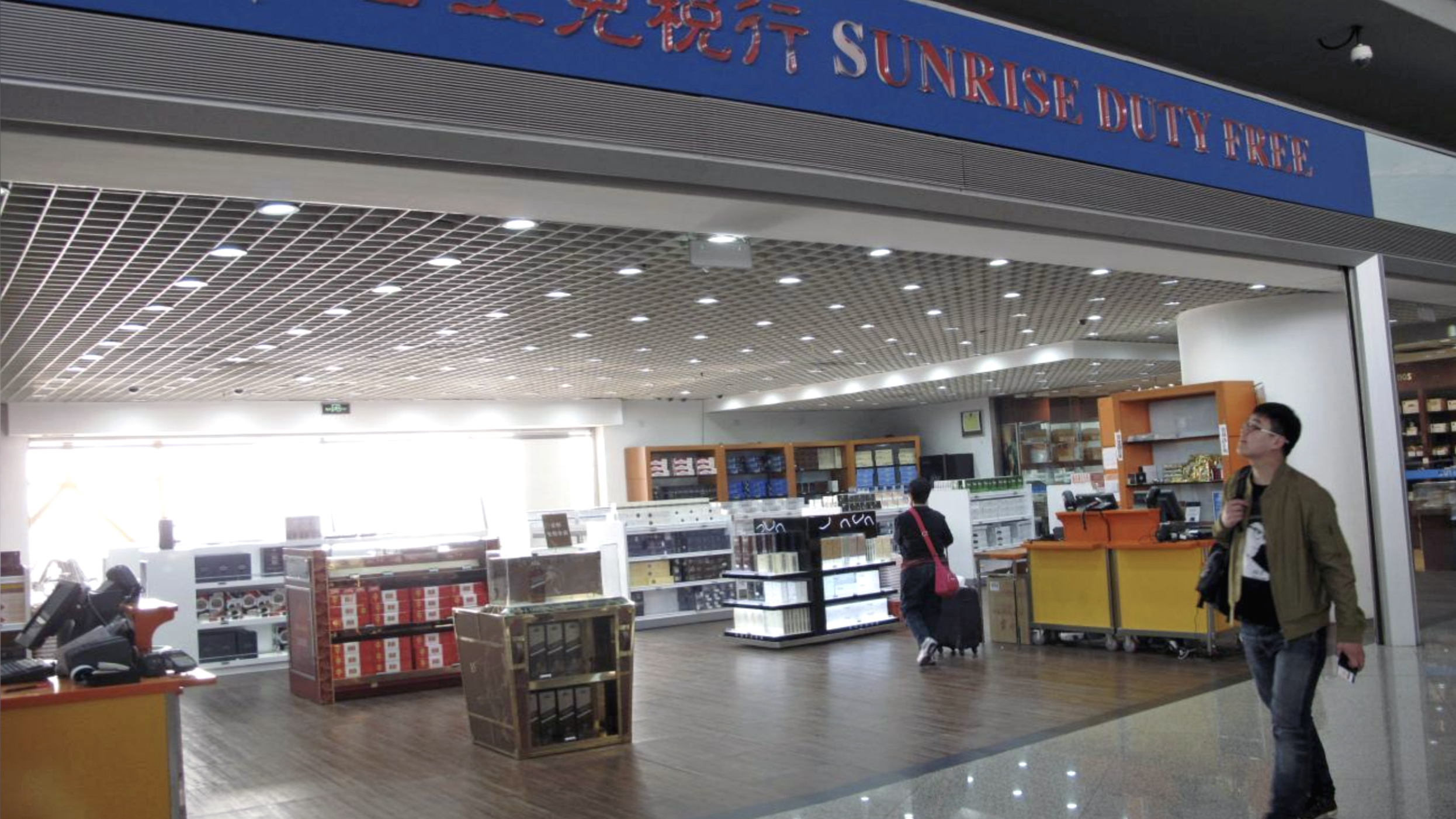 In this file photo, a traveler looks up as he walks past a Sunrise Duty Free shop at Beijing International Airport on March 14, 2014. (REUTERS)