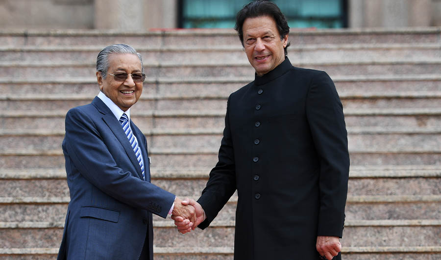 Malaysia's Prime Minister Mahathir Mohamad (L) shakes hands with his Pakistani counterpart Imran Khan during a welcoming ceremony at the prime minister's office in Putrajaya on November 21, 2018. (AFP)