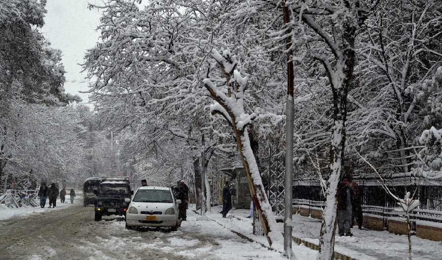 In this Sunday, Jan. 12, 2020, photo, people walk on a road during heavy snow fall in Quetta, capital of Pakistan's southwestern Baluchistan province. (AP)