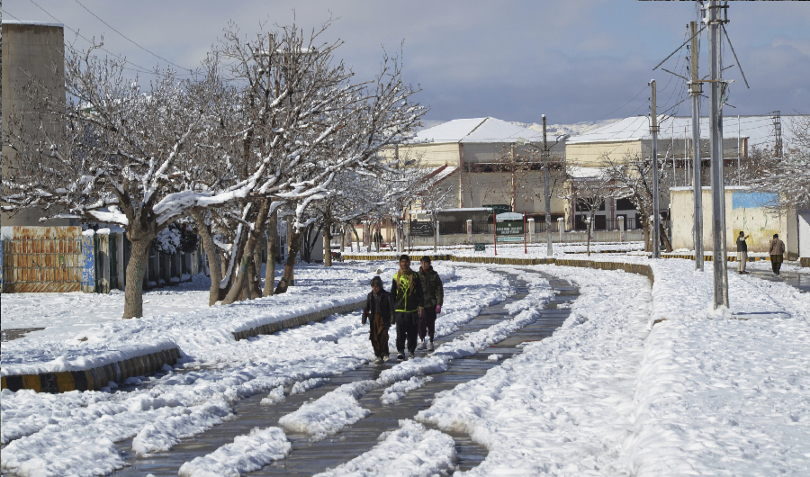 Youths walk on a snow-covered road after a heavy snowfall in Quetta, capital of Pakistan's southwestern Baluchistan province, Monday, Jan. 13, 2020. (AP)