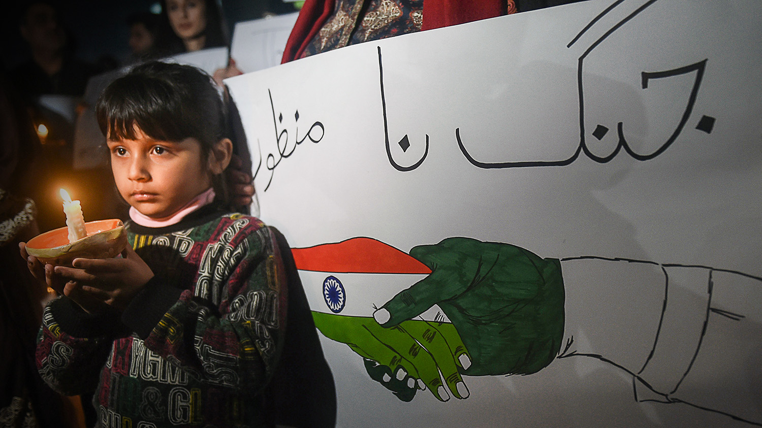 A Pakistani girl holds a candle during a vigil for peace between Pakistan and India in Lahore on March 3, 2019. (AFP)