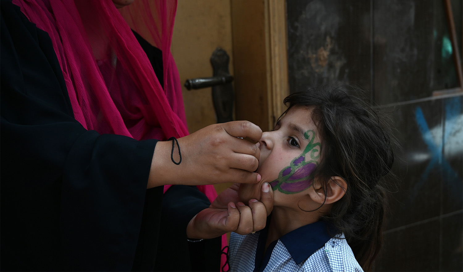 In this file photo, a Pakistani health worker administers polio vaccine drops to a child during a door-to-door polio immunization campaign on the outskirts of Islamabad on April 26, 2019. (AFP)