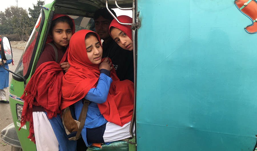 Schoolgirls board Arab Shah's auto-rickshaw in Pir Bala on the outskirts of Peshawar on Jan. 21, 2020. (AN photo)