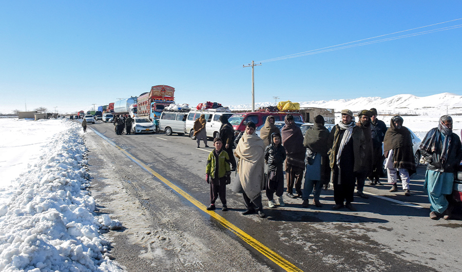 Travelers wait for the main highway to be cleared after heavy snowfall in Khanozai area, Balochistan, Jan. 14, 2020. (AFP)