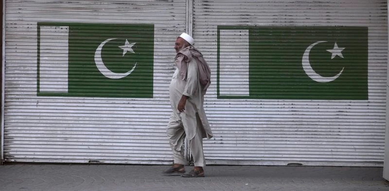 A man walks past a shop which is closed due to a strike in Peshawar, Pakistan, July 13, 2019. (AP Photo)