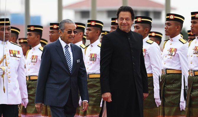 In this file photo, Pakistan’s Prime Minister Imran Khan is accompanied by his Malaysian counterpart Mahathir Mohamad as he reviews a guard of honor during a welcoming ceremony at the prime minister’s office in Putrajaya on Nov. 21, 2018. (AFP)