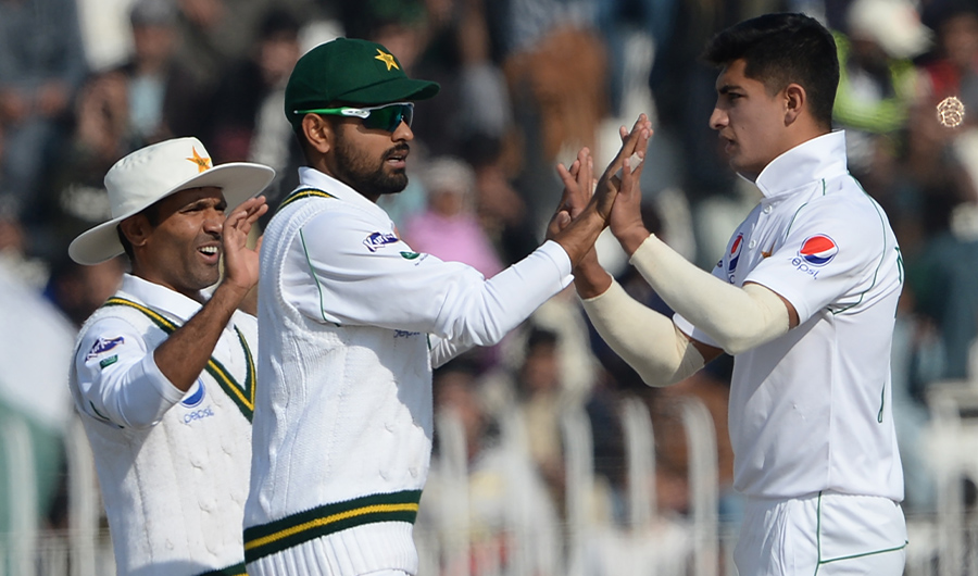 Pakistan's bowler Naseem Shah (R) celebrates with teammates Babar Azam (C) and Asad Shafiq after the dismissal of Bangladesh's Saif Hassan (unseen) during the third day of the first cricket Test match between Pakistan and Bangladesh at the Rawalpindi Cricket Stadium in Rawalpindi on February 9, 2020. (AFP)