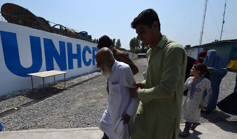 In this photograph taken on September 7, 2016, an Afghan refugee family leave after their registration at the United Nations High Commissioner for Refugees (UNHCR) repatriation centre on the outskirts of Peshawar. (AFP)