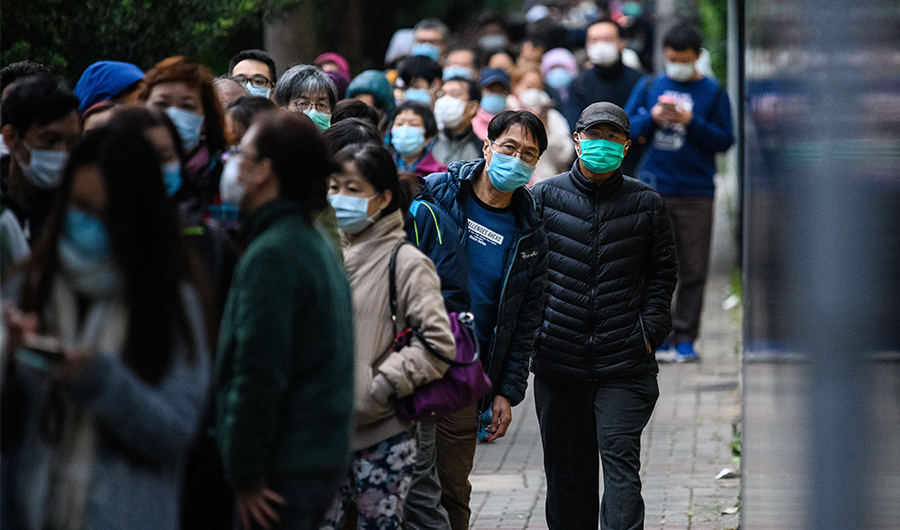 People wearing facemasks as a preventative measure following a coronavirus outbreak which began in the Chinese city of Wuhan, line up to purchase face masks from a makeshift stall on February 5, 2020. (AFP)
