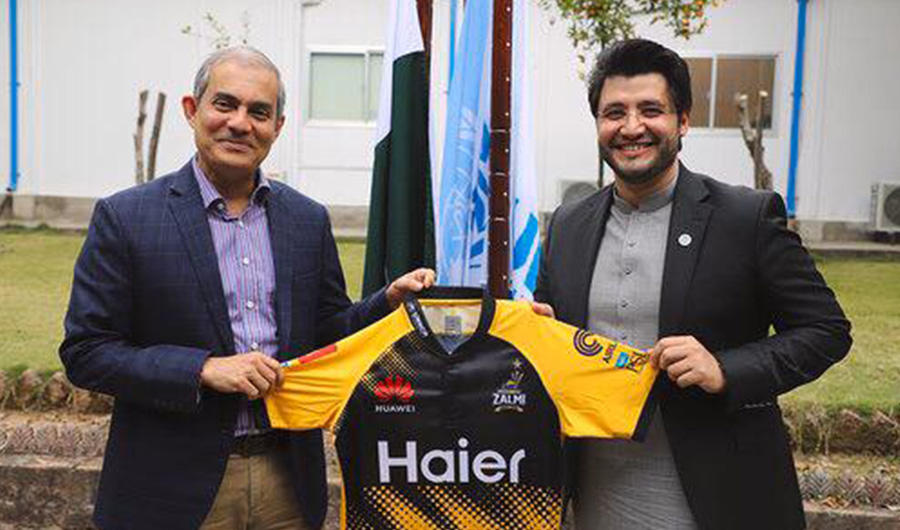 PSL franchise Peshawar Zalmi owner Javed Afridi holding official kit of Peshawar Zalmi with UNHCR logo with UN official on Feb 13, 2020. (Supplied)