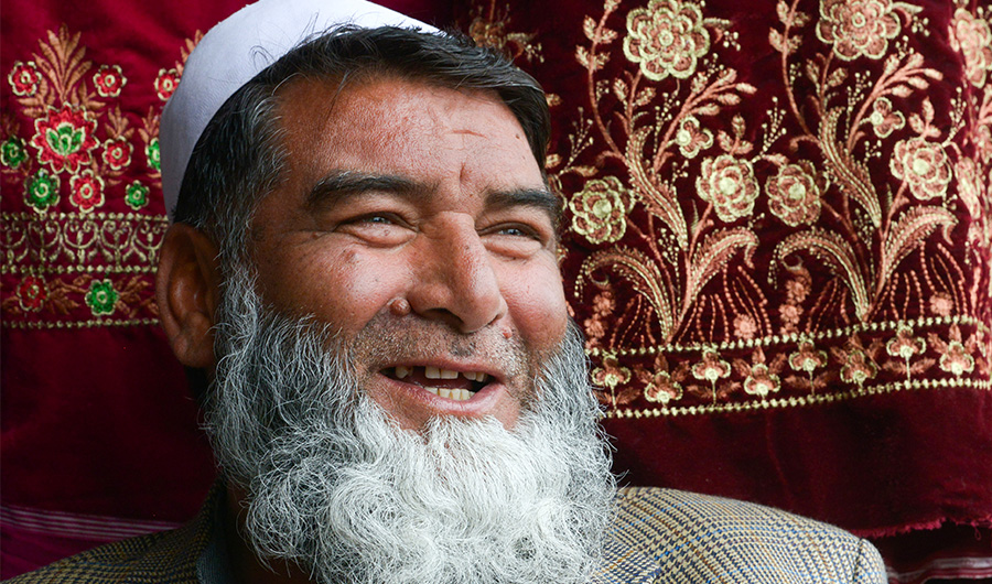 In this picture taken on February 12, 2020, Afghan refugee Mohammad Feroz smiles as he waits for customers at his clothing shop in a bazaar at a neighbourhood locally known as 'mini Kabul' in Peshawar. (AFP)