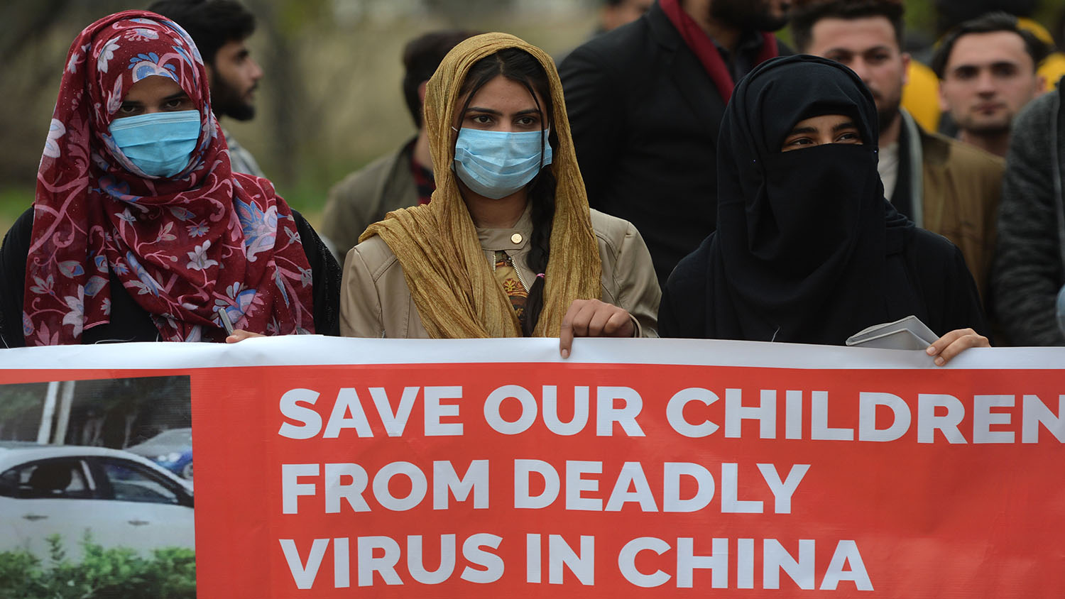 Parents and relatives of Pakistani students studying in the Chinese city of Wuhan, where the outbreak of the COVID-19 coronavirus began, stand behind a banner during a protest to demand the government the evacuation of their loved ones in Islamabad on Feb. 12, 2020. (AFP)