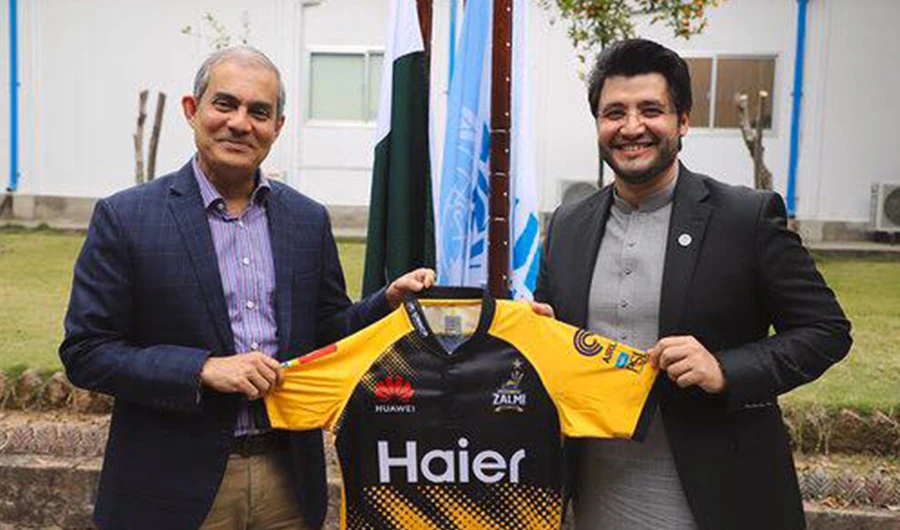 PSL franchise Peshawar Zalmi owner Javed Afridi holding official kit of Peshawar Zalmi with UNHCR logo with UN official on Feb 13, 2020. (Supplied)