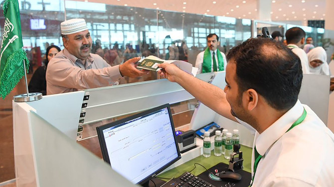 This undated file photo shows a Saudi immigration officer returning passport to a Pakistani pilgrim at Islamabad airport. (SPA)