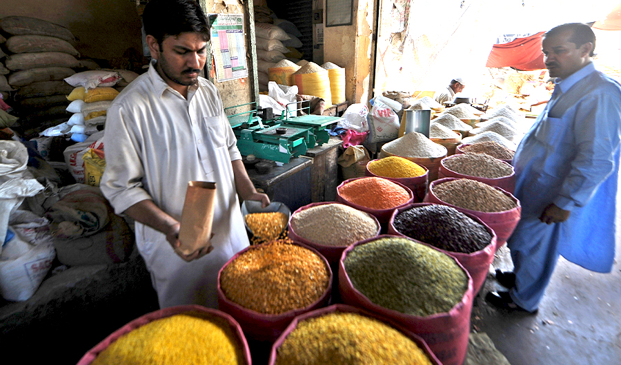 A Pakistani salesman sells pulses to a customer at a grocery shop in Karachi on April 29, 2008. (AFP)