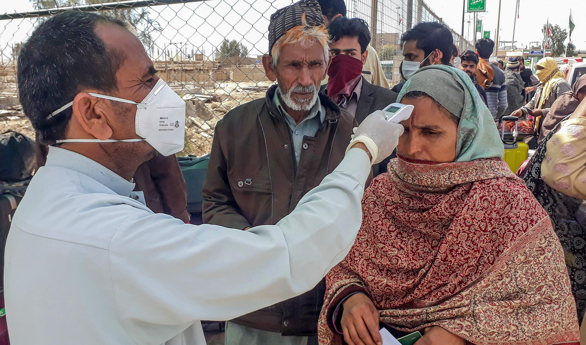 In this file photo, a health personnel checks the body temperature of a pilgrim returning from Iran via the Pakistan-Iran border town of Taftan on Feb. 29, 2020. (REUTERS)
