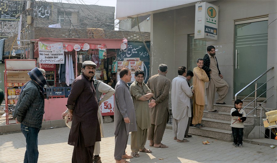 Pakistanis wait in line to withdraw money from an automated teller machine (ATM) during a public holiday in Rawalpindi on March 2, 2014. (AFP)