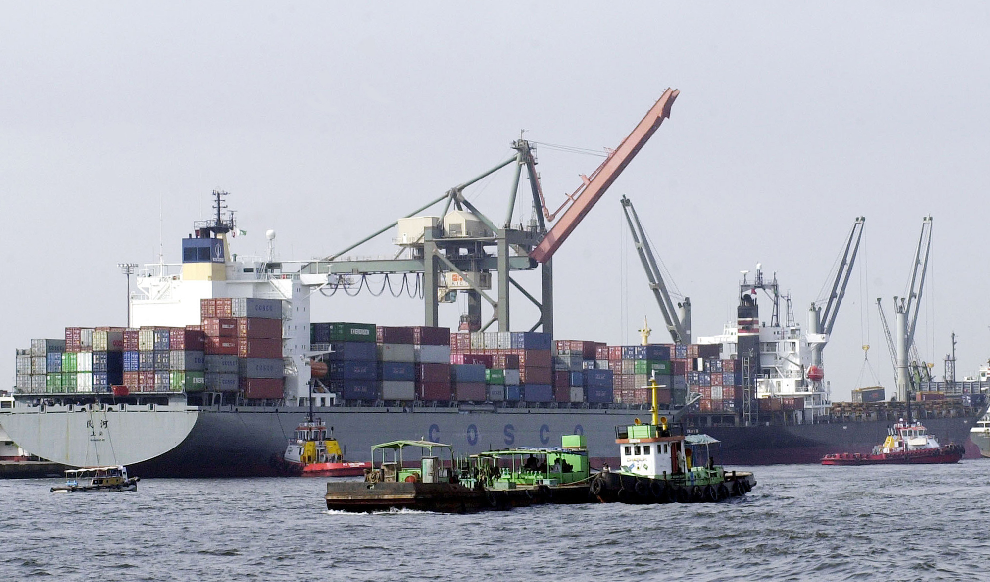 In this file photo, Pakistani vessels pass by container ships being loaded with cargo at the port of Karachi on Sept 8, 2003. (AFP)