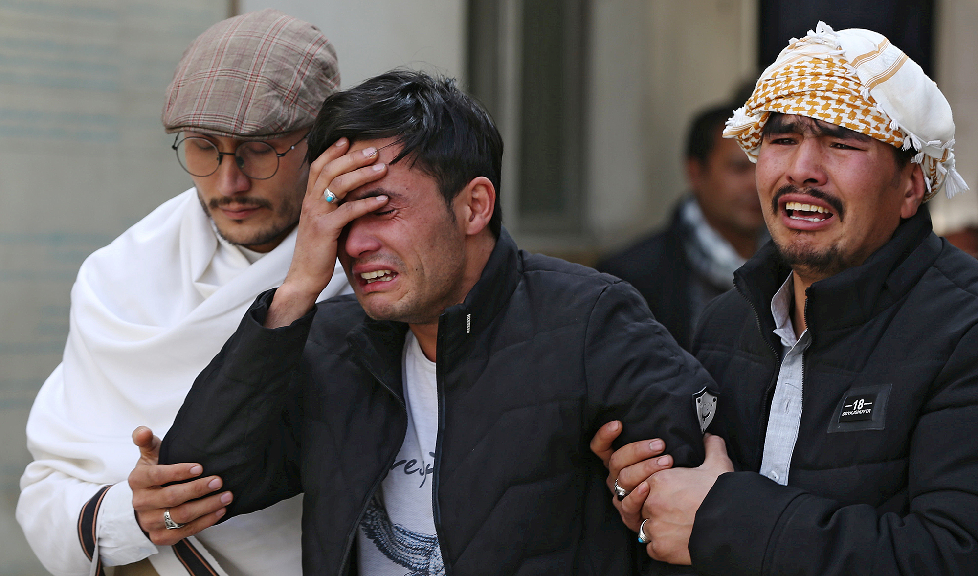 Afghan men cry at a hospital after they heard that their relative was killed during an attack in Kabul, Afghanistan March 6, 2020. (REUTERS)