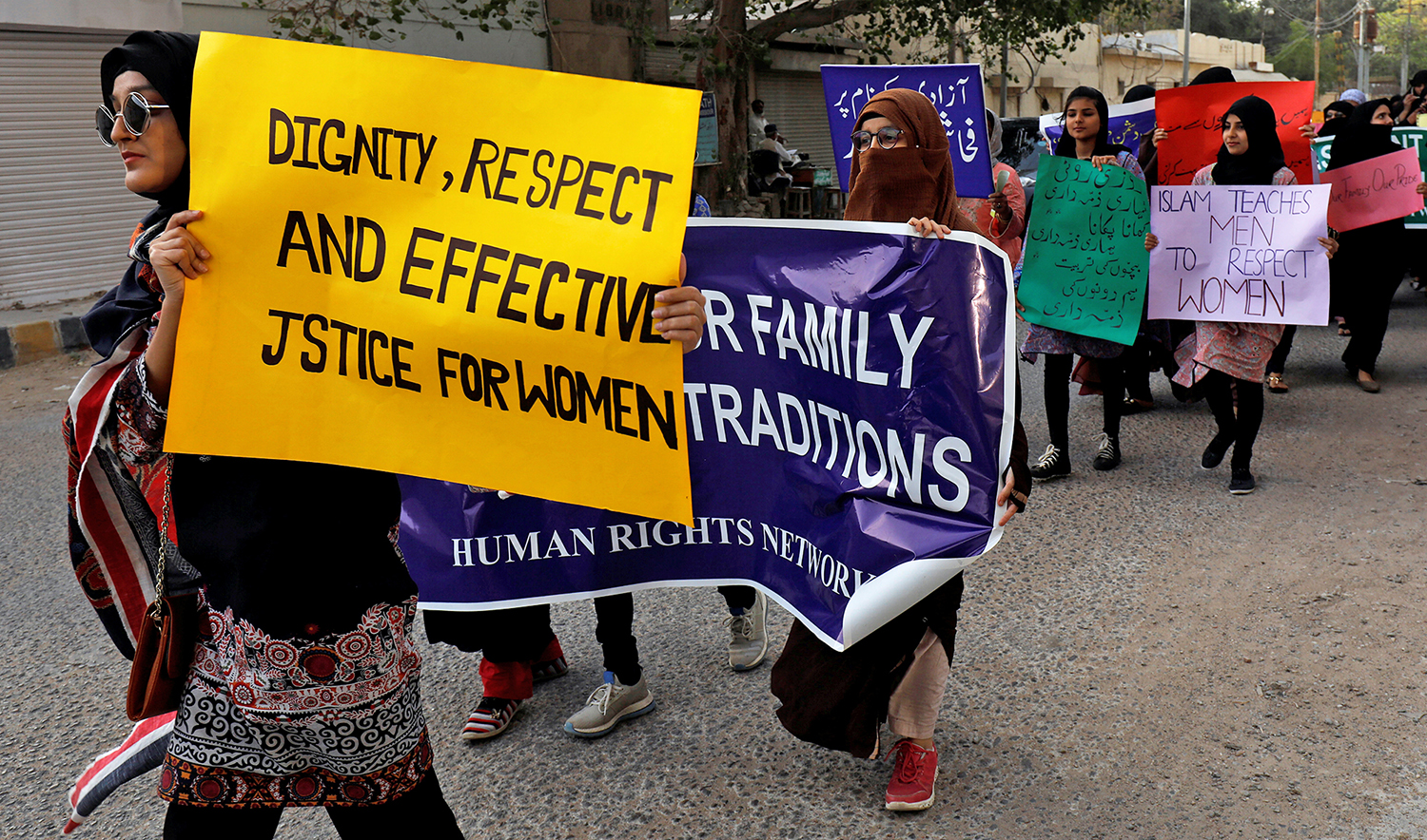 Women carry signs as they take part in a march demanding equal rights, ahead of international women's day in Karachi on March 6, 2020. (REUTERS)