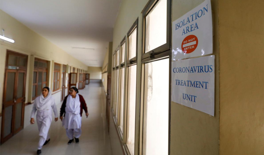 Paramedic staff walk at an isolation section, set up for the precautionary measures for the coronavirus patients treatment, at the Jinnah Postgraduate Medical Center in Karachi. (Reuters)