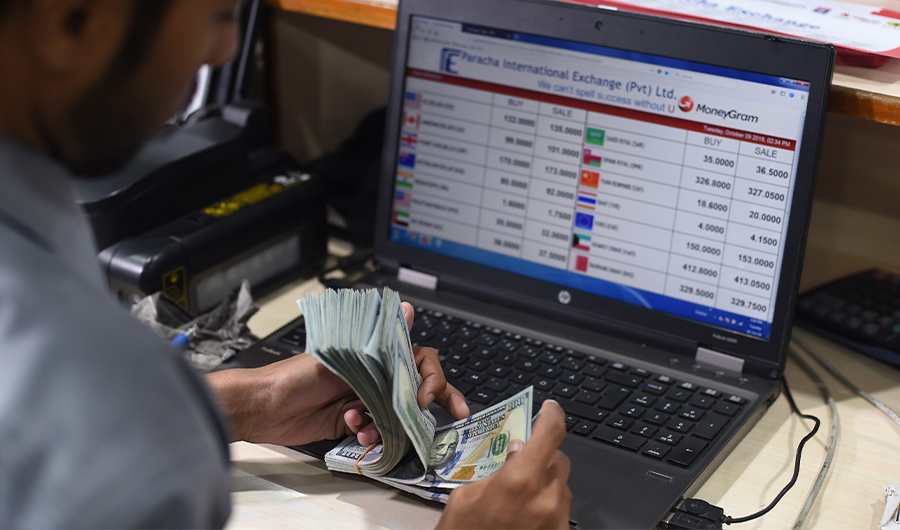 A Pakistani dealer counts US dollars at a currency exchange shop in Karachi on October 9, 2018. (AFP)