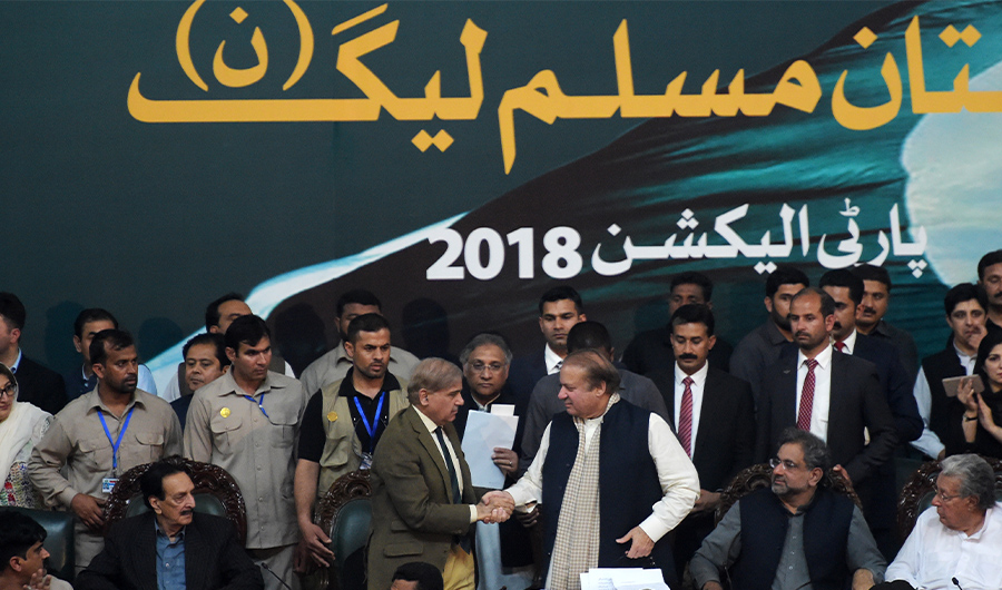Pakistani Chief Minister of Punjab province Shahbaz Sharif, shakes hands with his brother and ousted prime minister Nawaz Sharif (3R) while Prime Minister of Pakistan Shahid Khaqan Abbasi (2R) looks on, after being elected President of ruling Pakistan Muslim League-Nawaz (PML-N) party at the General Workers Council in Islamabad on March 13, 2018. (AFP)